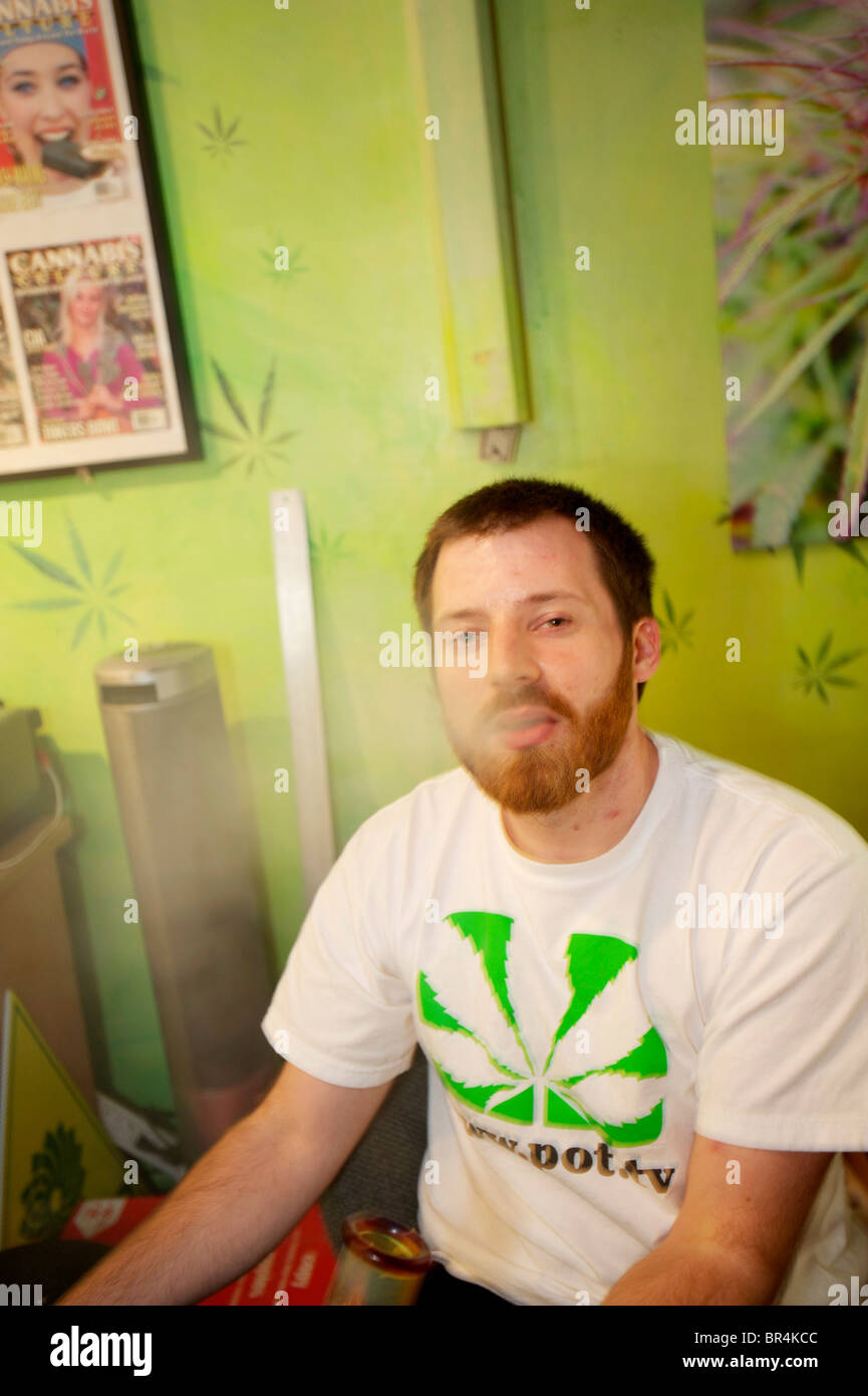 A marijuana advocate blows smoke after smoking from a giant bong water