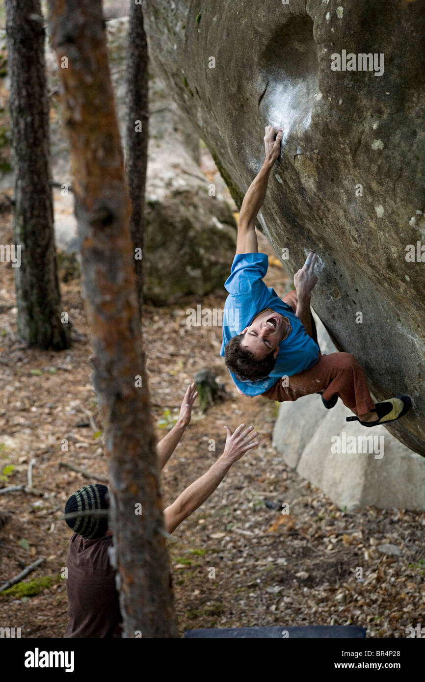 Rock climber screaming while attempting to hold a very slippery handhold. Stock Photo