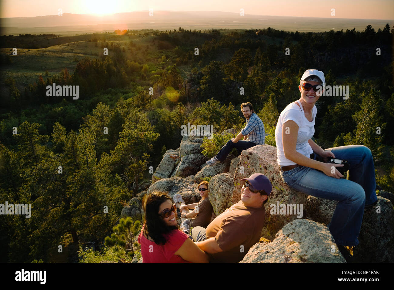 Friends resting on rocks in remote area Stock Photo