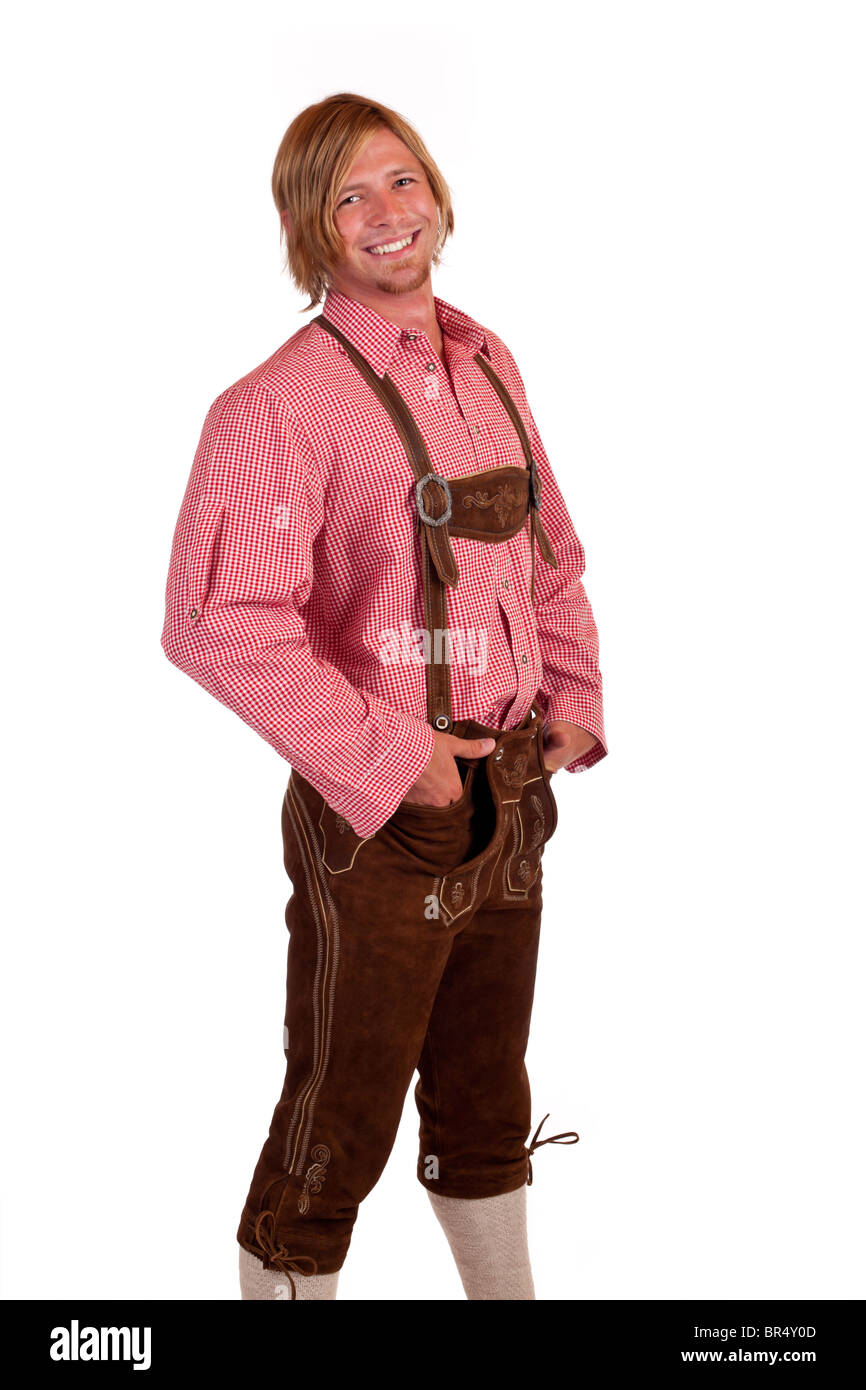 Bavarian man with oktoberfest leather trousers (lederhose) holds suspenders. Isolated on white background. Stock Photo