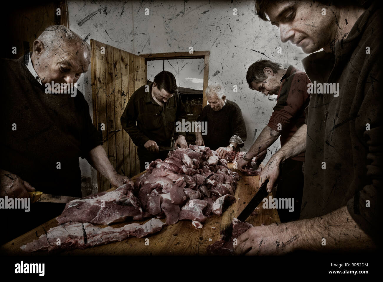 Five people cutting the meat of the slaughtered pig. Stock Photo