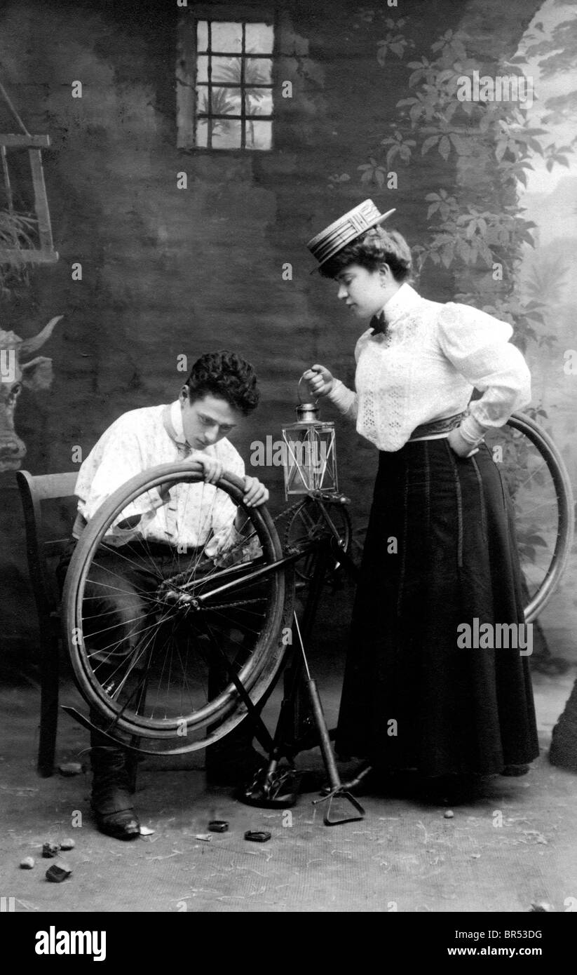 Historic photograph, man repairing a woman's bicycle, around 1912 Stock Photo
