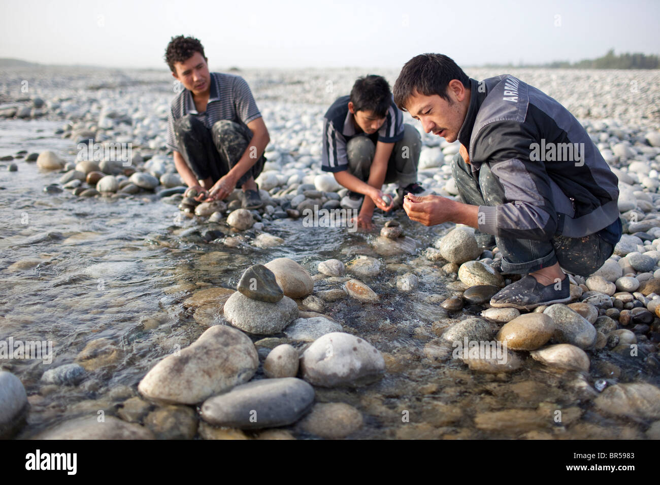 Young men looking for jade in river near Hotan Xinjiang China. Stock Photo