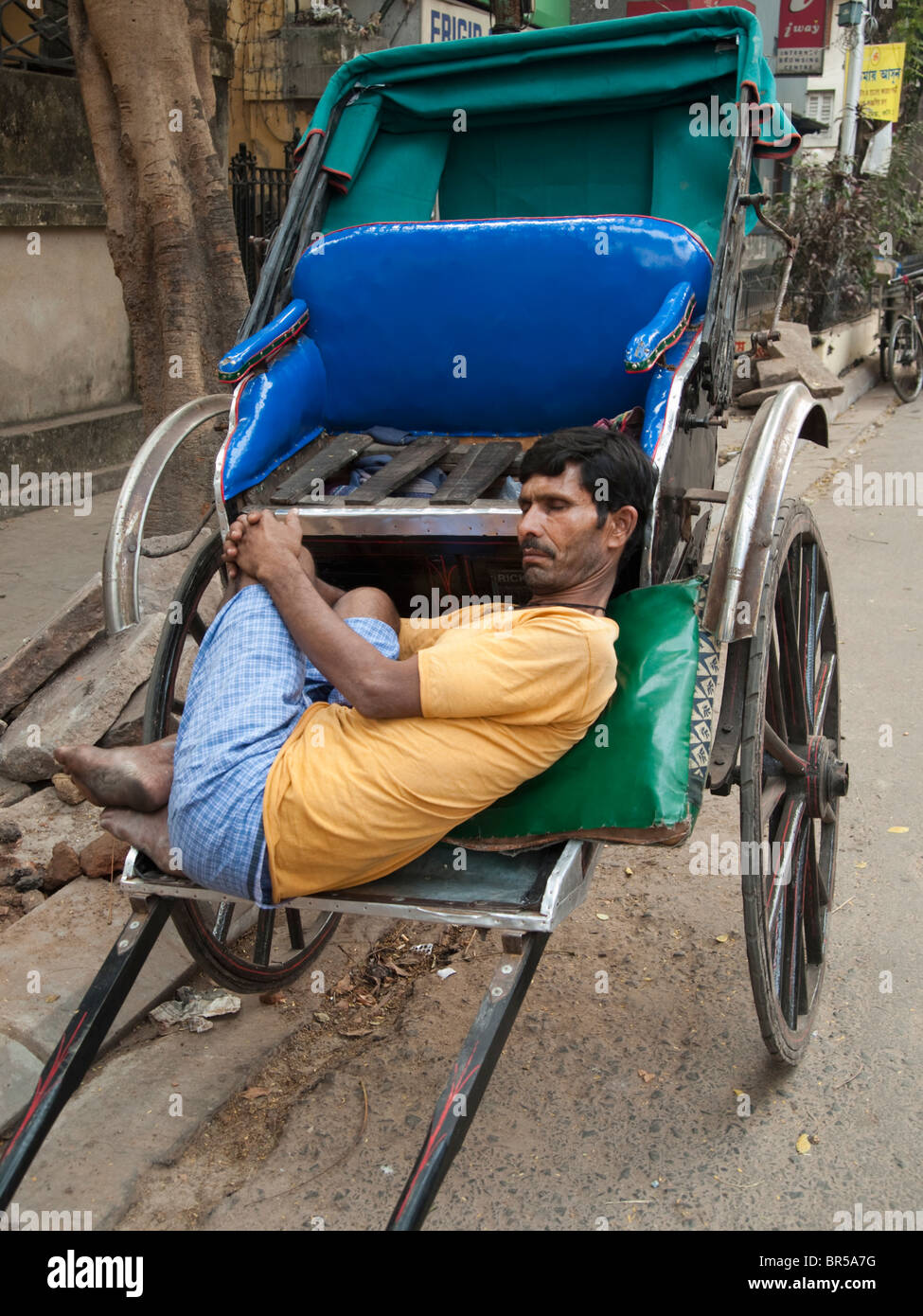 Rickshaw puller rests in his rickshaw Stock Photo Alamy
