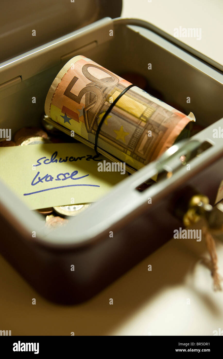 Money in a cash box, 'Schwarze Kasse', black money written on a piece of paper Stock Photo