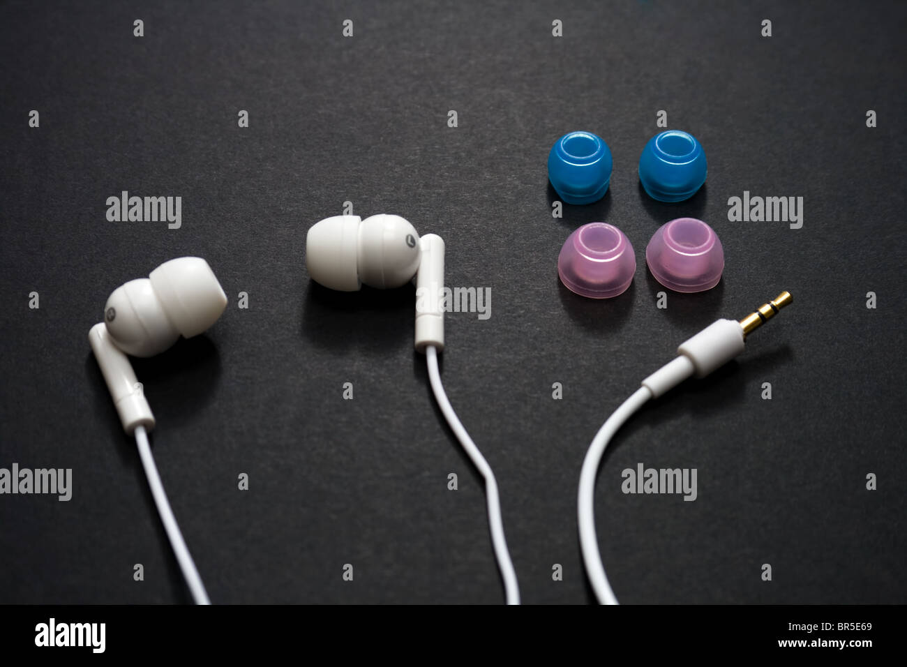 White earbuds and spare parts on a dark background Stock Photo Alamy