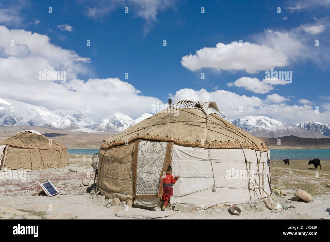 Kirghiz people's yurts by Karakuli Lake, Mt. Kunlun in the distance, Pamir Plateau, Xinjiang, China Stock Photo