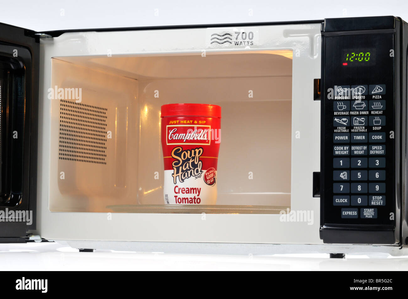 Package of Campbell's creamy tomato soup at hand instant microwaveable soup in microwave. Stock Photo