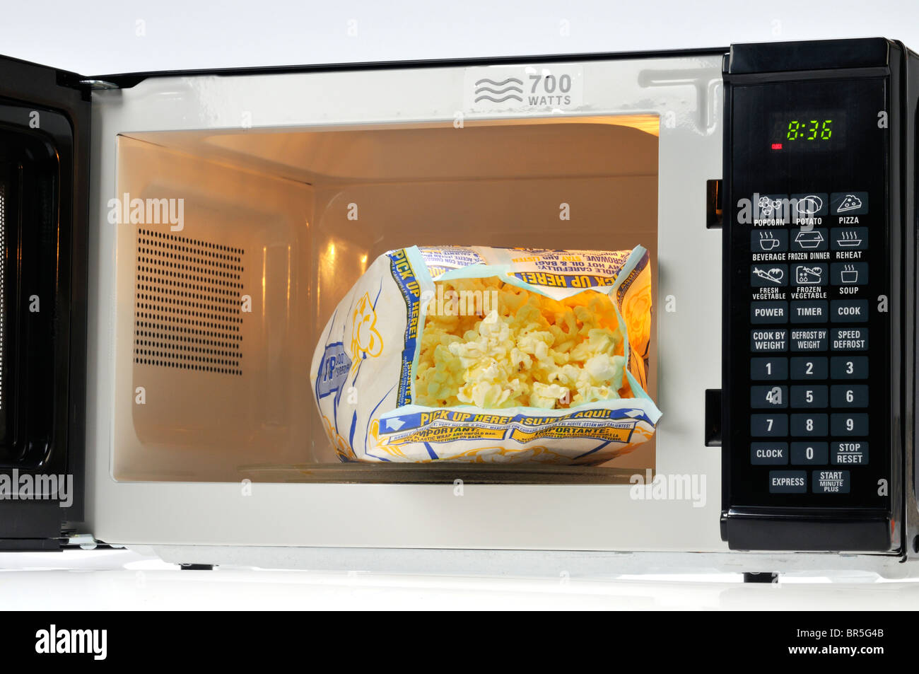 Open bag of Pop Secret microwave popcorn in microwave oven, USA. Stock Photo