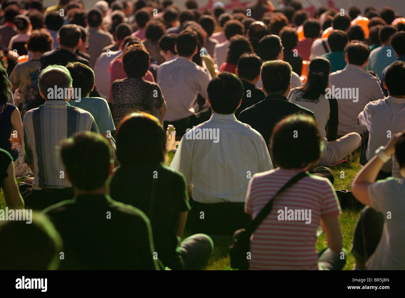 Audience listening at an open air music concert, in the evening, in ...