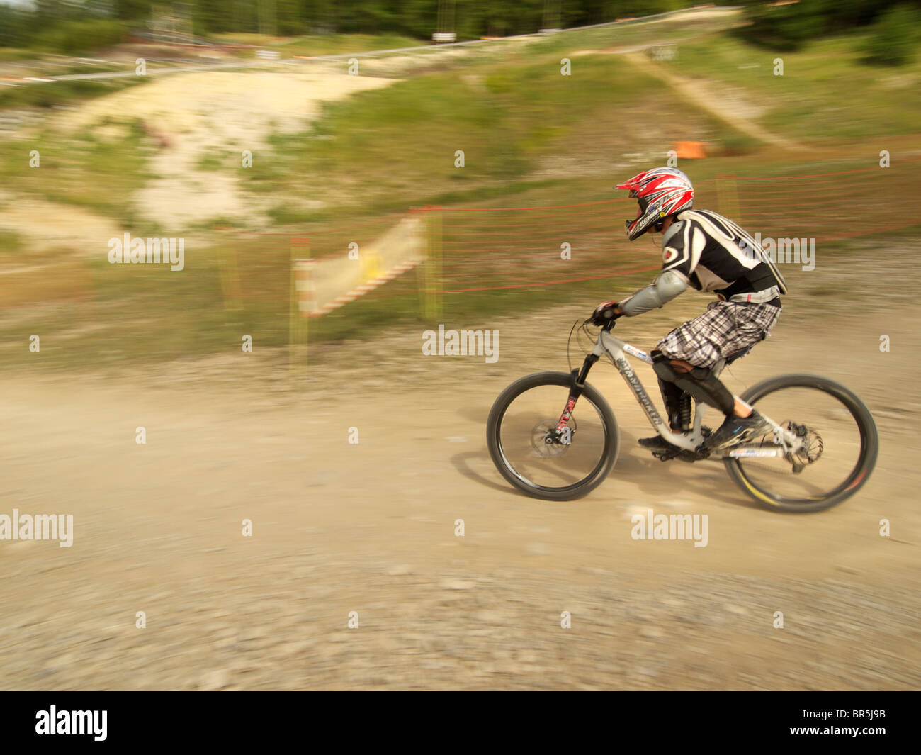 Speeding mountainbike rider going downhill with blurred background in Les Orres, Hautes Alpes