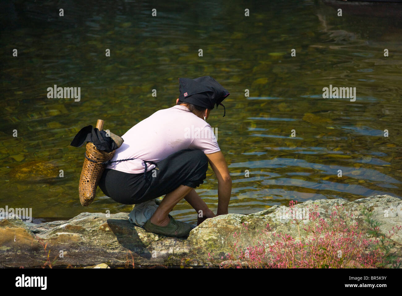 Red Yao woman washing by the water, Longsheng, Guangxi, China Stock Photo
