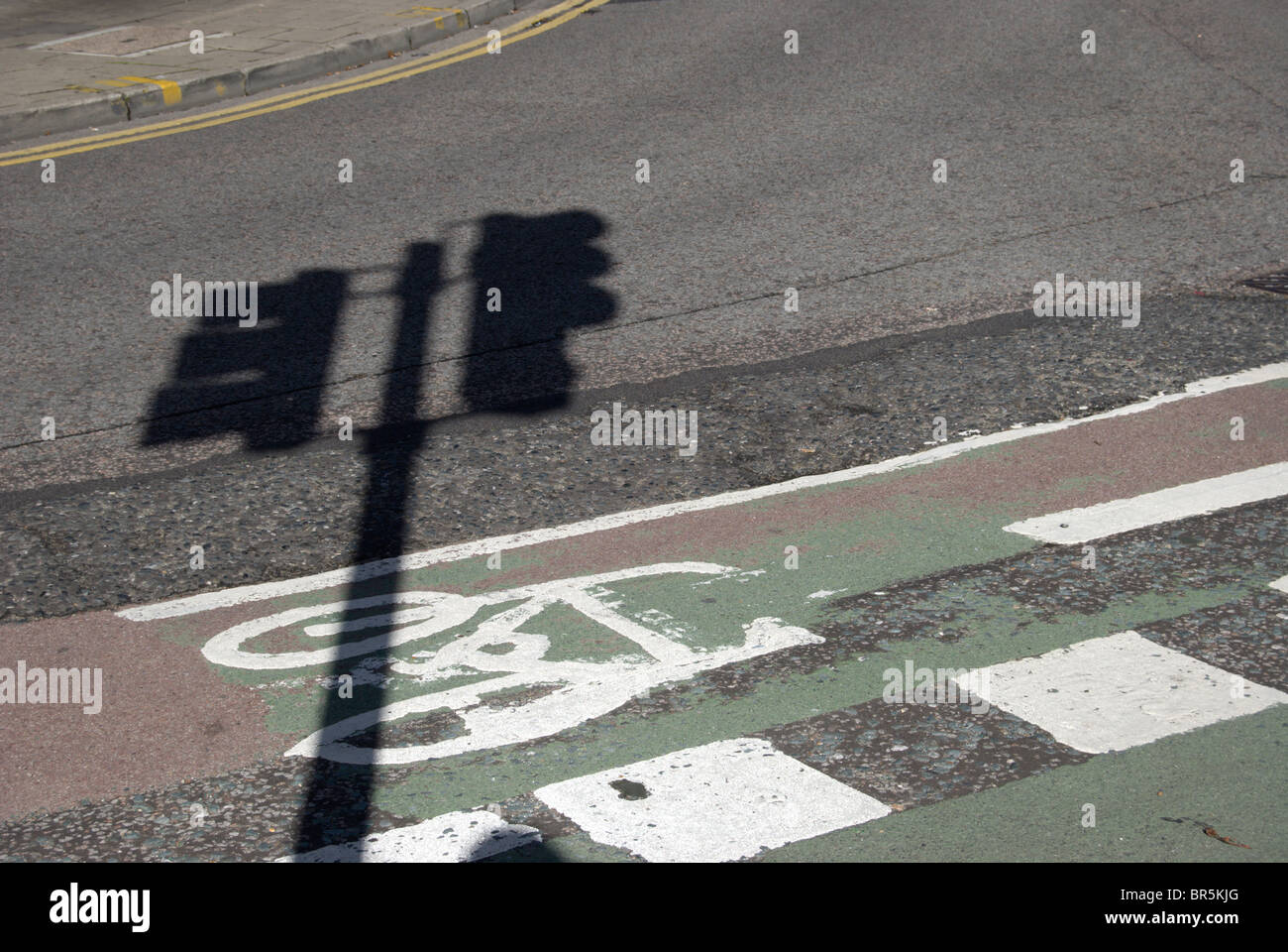 shadow cast by a pair of traffic lights across a cycle lane in kingston