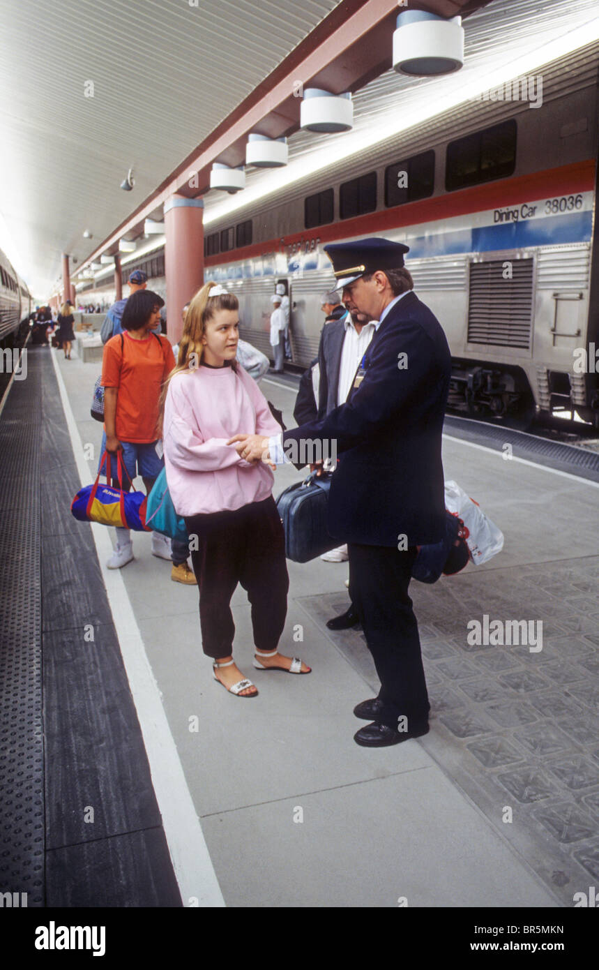 conductor help assist aid information question employee train rain Amtrak Los Angeles California passenger girl Stock Photo