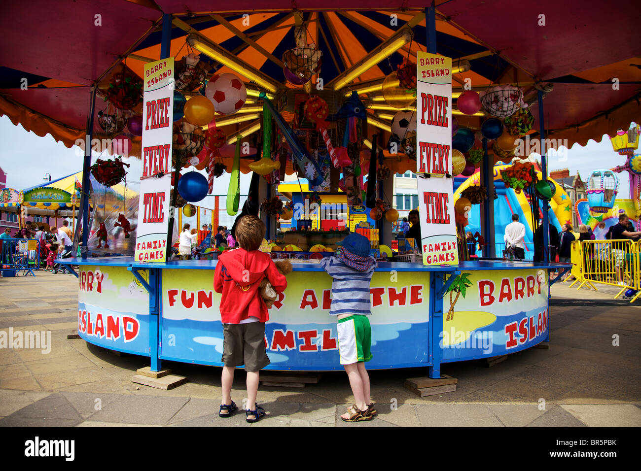 Two young boys having a go on the colourful Hook a Duck fairground