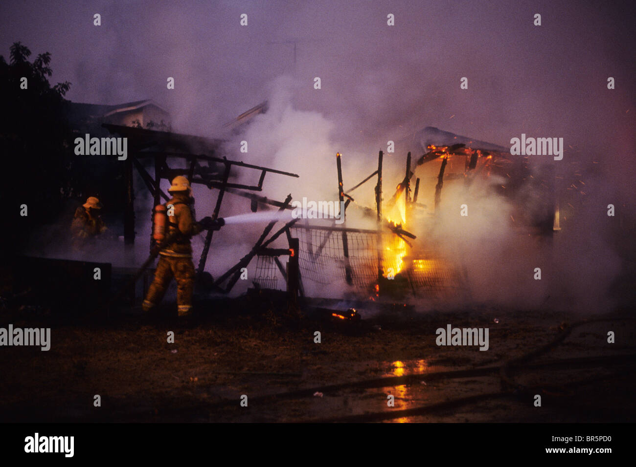 Fire destroy house home emergency 9-1-1 911 fighter fireman hose water fight flame smoke risk danger Stock Photo