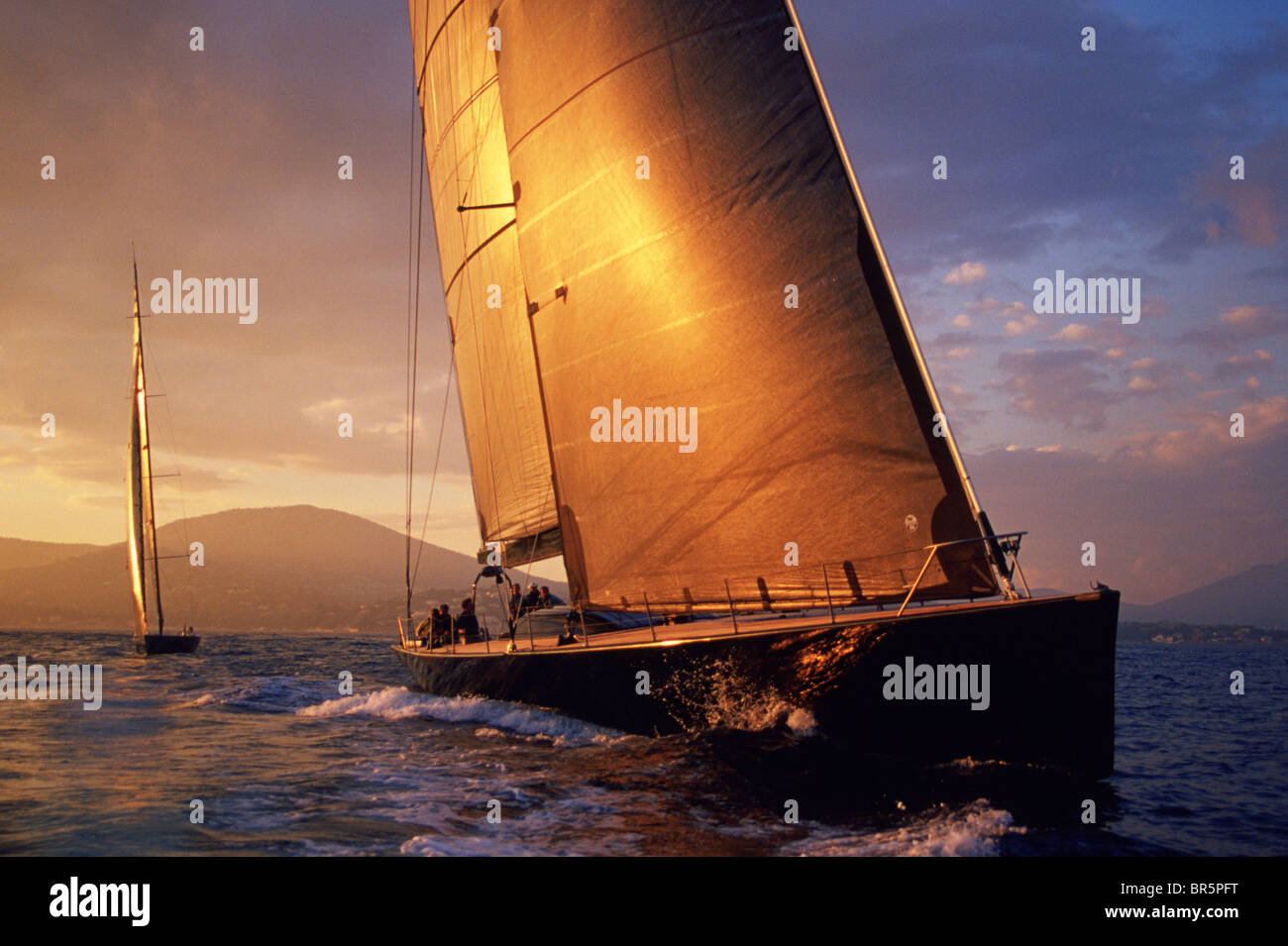 Sailboat racing at sunset. Stock Photo