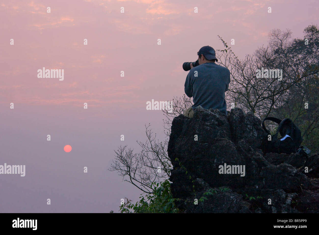 Tourist photographing sunrise, Yangshuo, Guangxi, China Stock Photo
