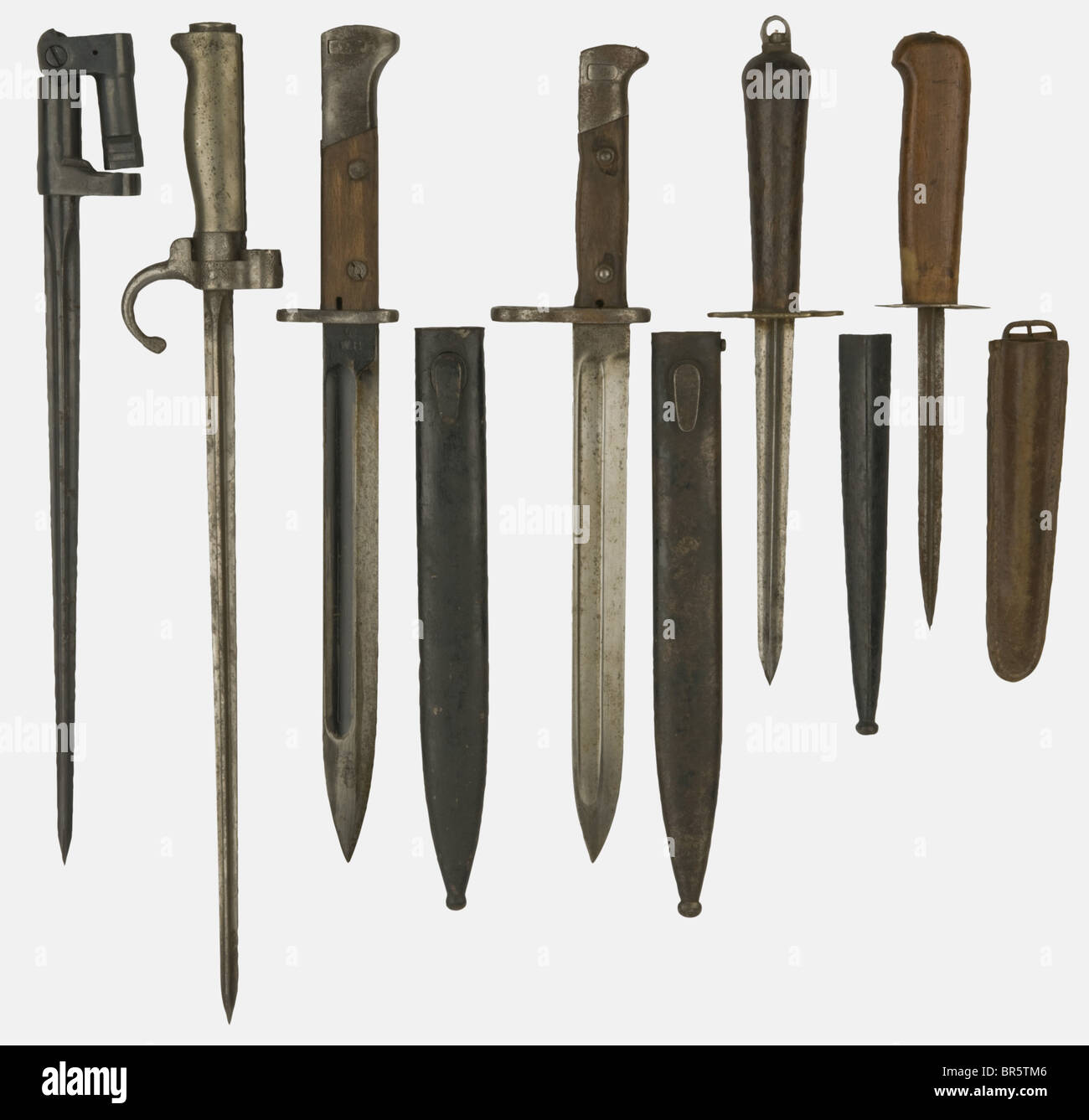 A group of edged weapons, including a first pattern German bayonet 1871/84 stamped on the blade 'Simson & c SUHL' with wooden grip scales and steel scabbard, a French Lebel bayonet, shortened blade model, with white metal handle, no scabbard, a Mosin-Nagant pattern 44 spike bayonet with its gun holding device, a French First World War trench fighting knife, blade made of a sword blade, oval handguard with stamping 'CV', wooden handle, leather scabbard, strap missing, a French navy dagger pattern 1833 with triangular blade, brass handguard with anchor reception , Stock Photo