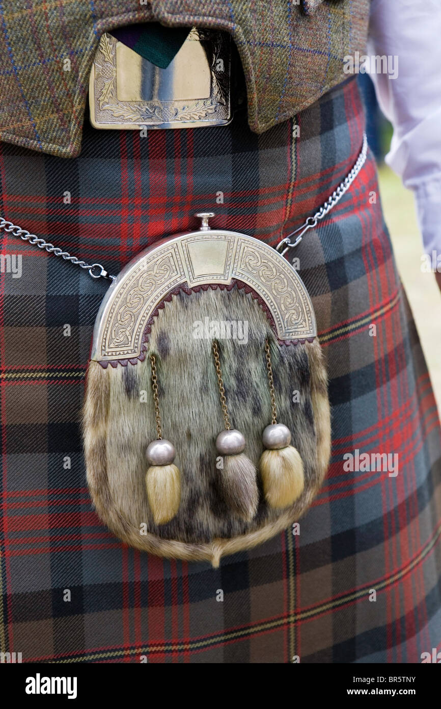 A fur Sporran hangs by a chain round the waist of a man wearing a woollen tartan kilt, in Rockness, Scotland. Stock Photo