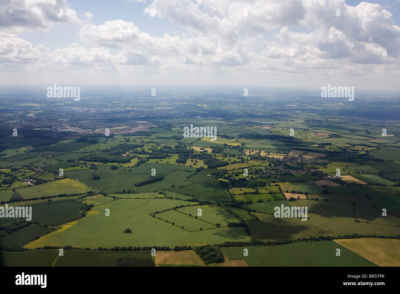Clouds float over a landscape of green fields. A classic English scene. Stock Photo