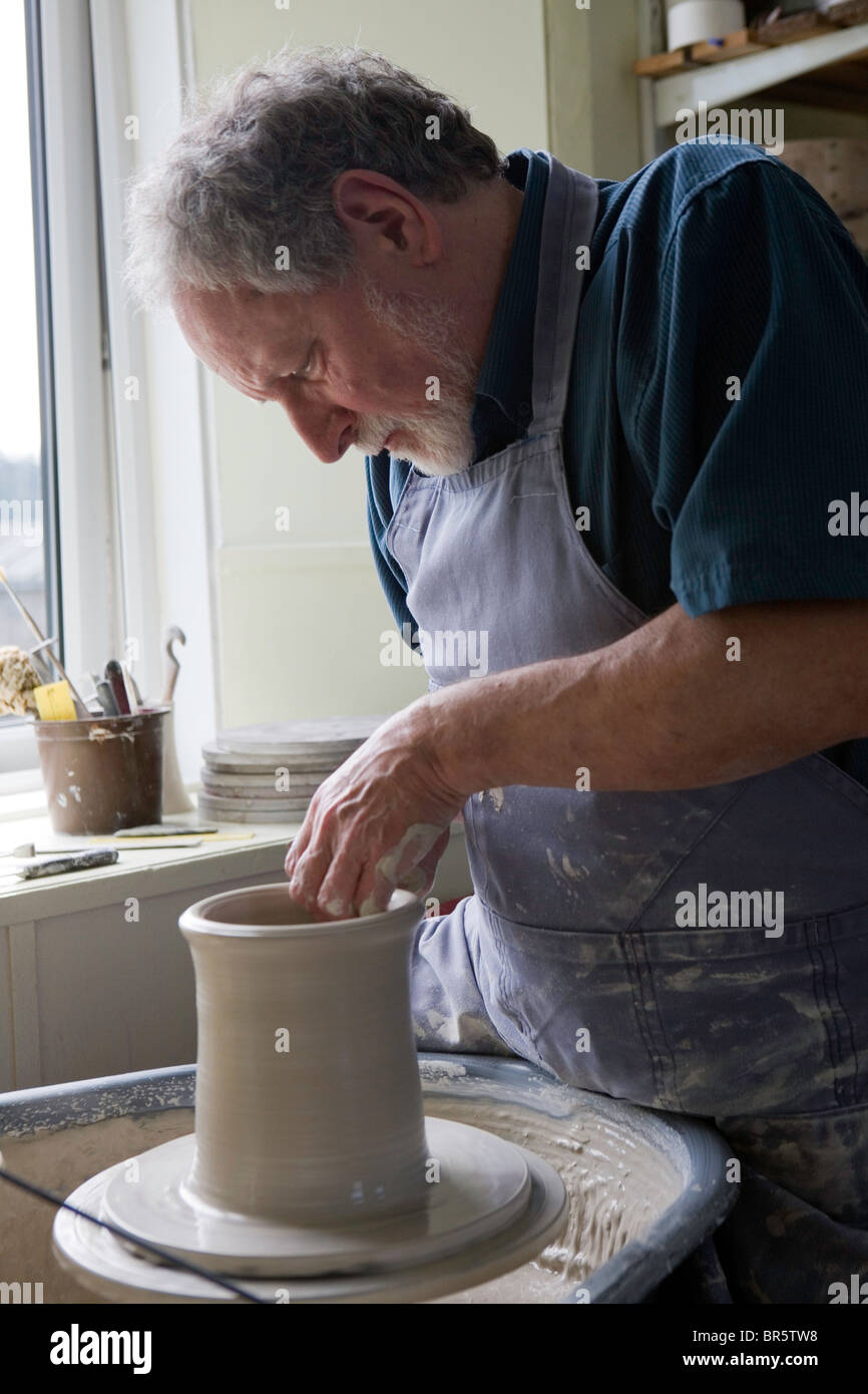 A potter working with clay at his wheel in Pinmore ceramics gallery