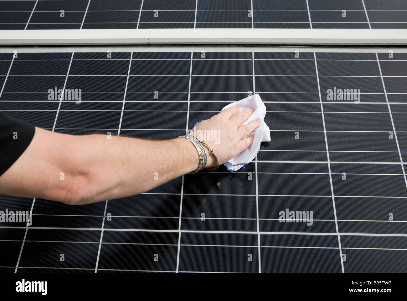 Close-up of a photovoltaic solar energy panel with reflection of the sun. This panel, or module, is made up of PV cells. Stock Photo