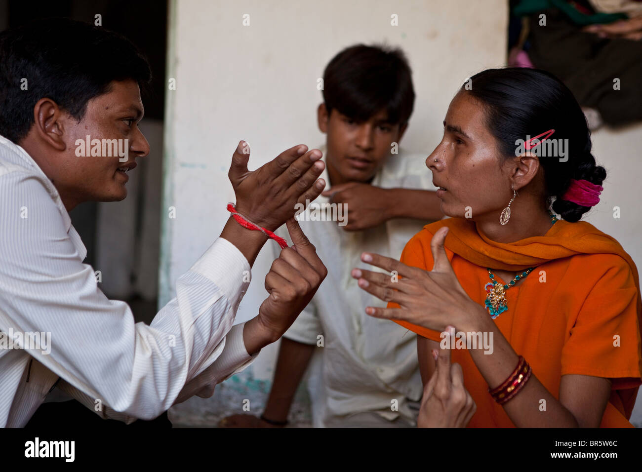 Deepak works with 16-year-old Hansa who is deaf and blind. They are learning tactile sign language. Ahmedabad, India. Stock Photo