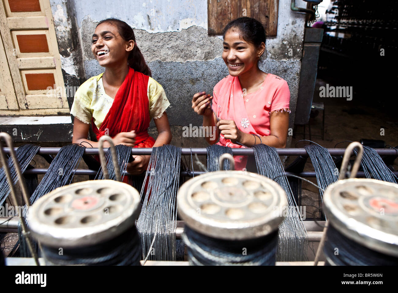 Two young women making plastic string in the city of Bhavnagar, Gujarati State. Child labour is common in this area. Stock Photo