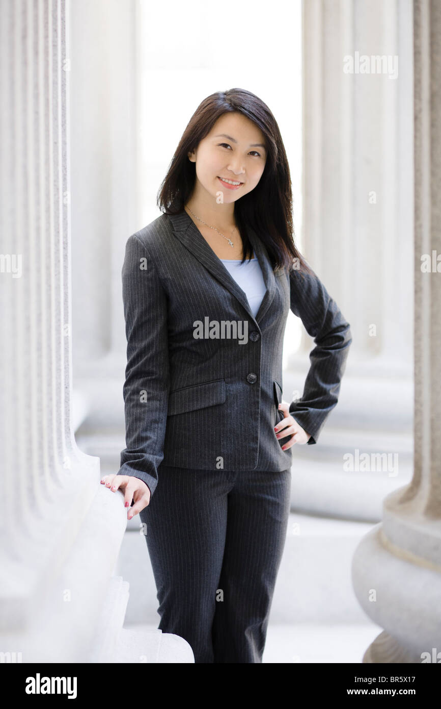 Chinese businesswoman standing near stone pillars Stock Photo