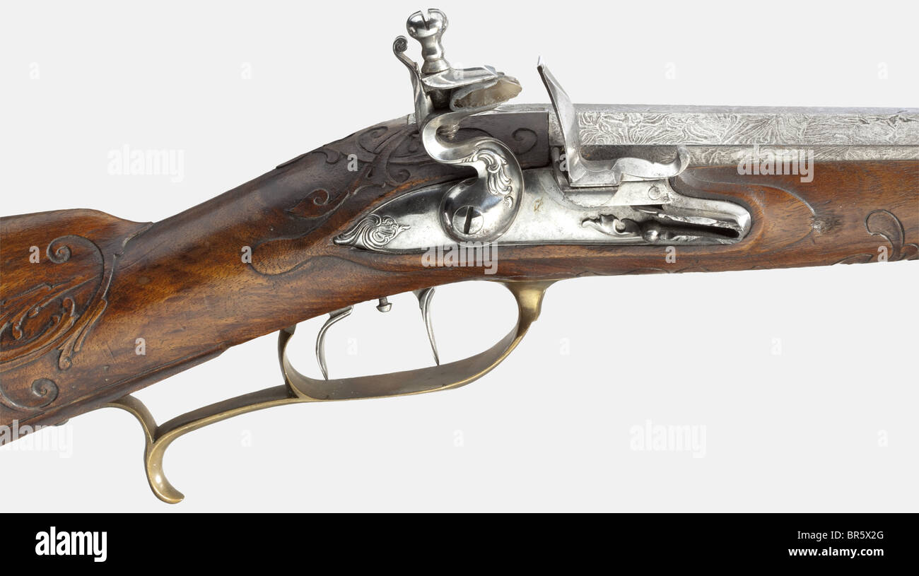 A pair of short flintlock rifles with Damascus barrels, German, circa 1780. Octagonal, twist Damascus barrels, slightly constricted in the middle, with eight-groove rifled bores in 13 mm calibre, and finely cut dovetailed sights. Flintlocks cut with rocaille decoration. Double set triggers. Walnut stocks with horn nose caps and fine raised vine carving. Patchboxes with fluted lids. Smooth brass furniture. Wooden ramrods with horn tips. Length of each 77.5 cm. historic, historical, 18th century, civil long guns, gun, weapons, arms, weapon, arm, firearm, fire arm, Stock Photo