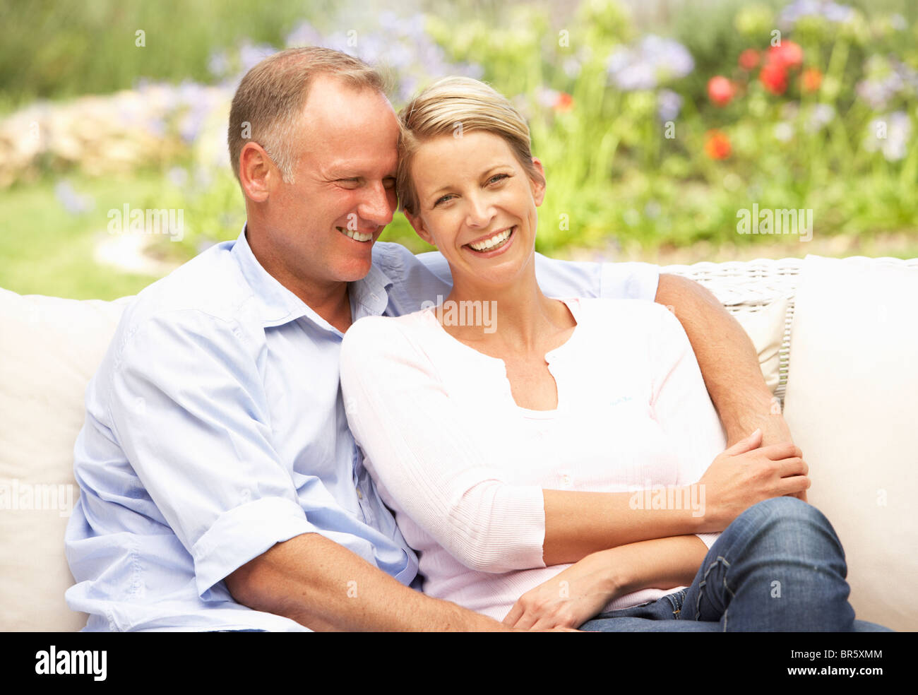 Couple Relaxing In Garden Stock Photo - Alamy