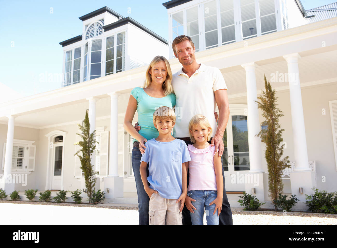 Young Family Standing Outside Dream Home Stock Photo - Alamy