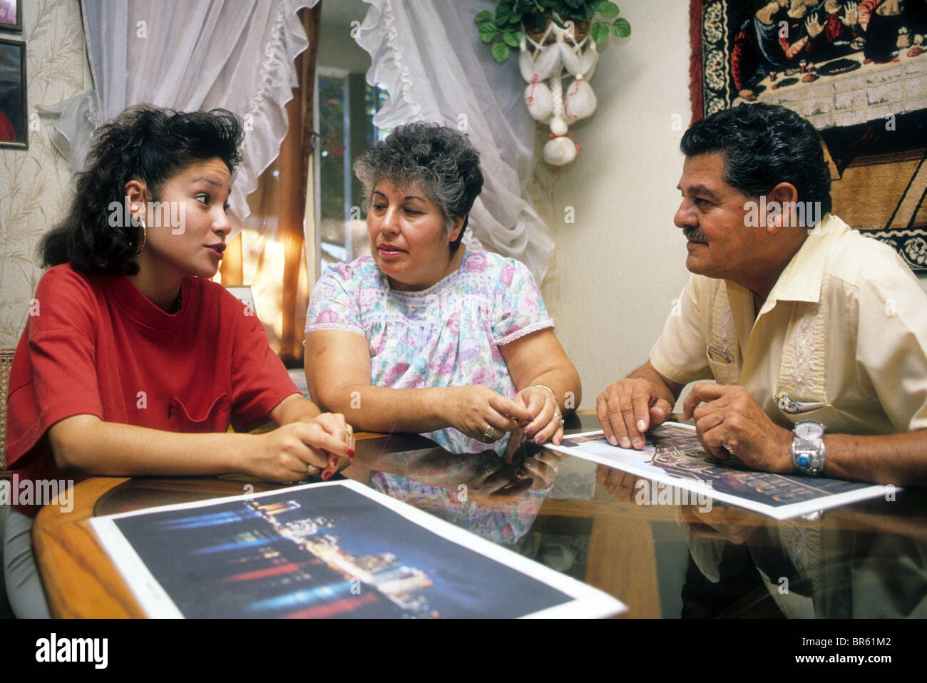 Hispanic mother and father talk with daughter at table converse share  communicate visit discuss Stock Photo - Alamy