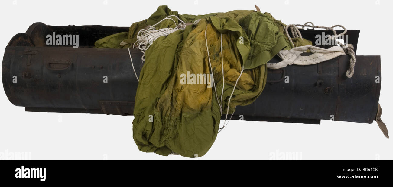A British dropping container type C, of sheet metal, complete with closing devices and handles, dark green paint at 50%, markings found inside 'L.15225', and its hinges. Also included are its olive green silk canopy, its parachute bag, lines and SOA. historic, historical, 1930s, 1930s, 20th century, technical, technic, material, materials, device, devices, equipment, equipments, utensil, piece of equipment, utensils, technology, militaria, military, object, objects, stills, clipping, clippings, cut out, cut-out, cut-outs, Stock Photo