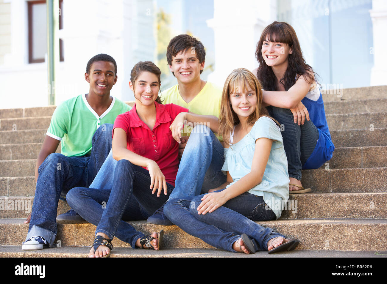 Group Of Teenage Friends Sitting On College Steps Outside Stock Photo