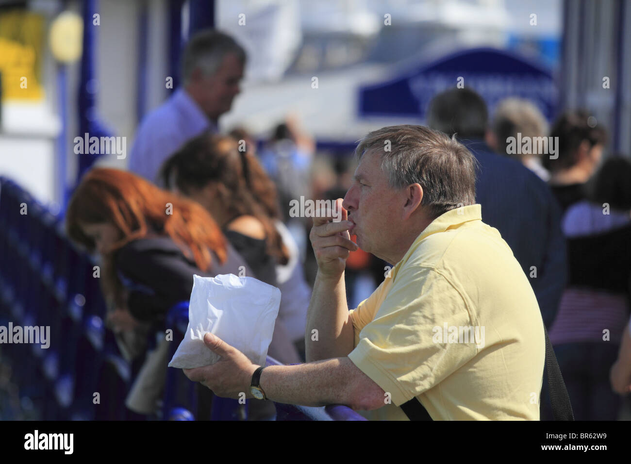 A man enjoys some fish and chips on Eastbourne Pier, East Sussex, England. Stock Photo