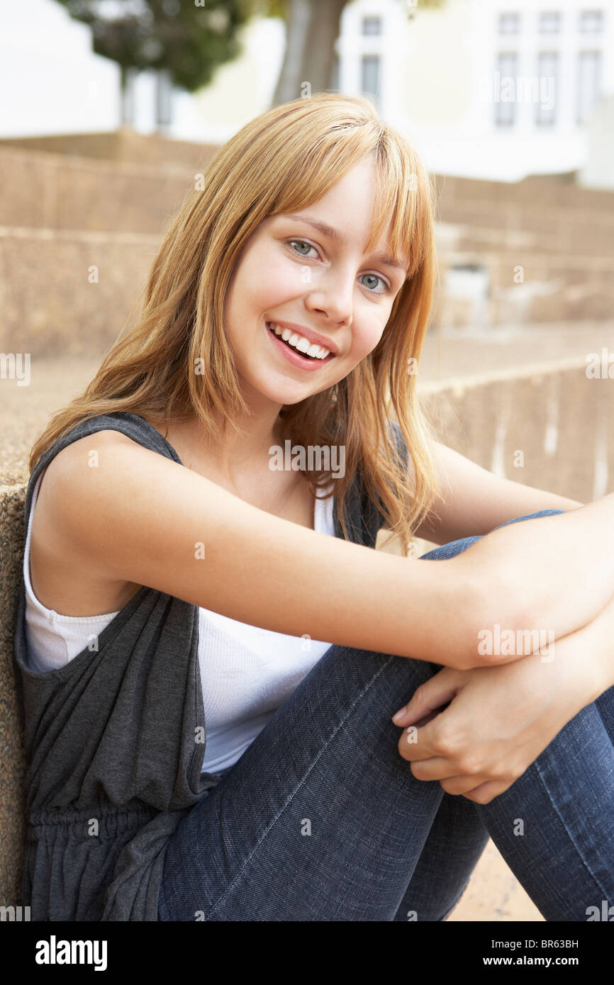 Smiling Teenage Student Sitting Outside On College Steps Stock Photo