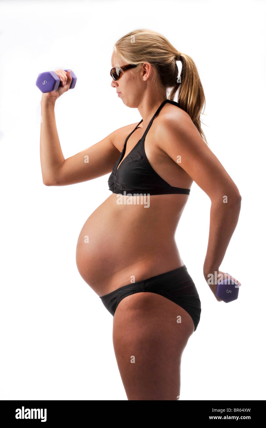 pregnant woman with props and black bathing suit on white background. Stock Photo