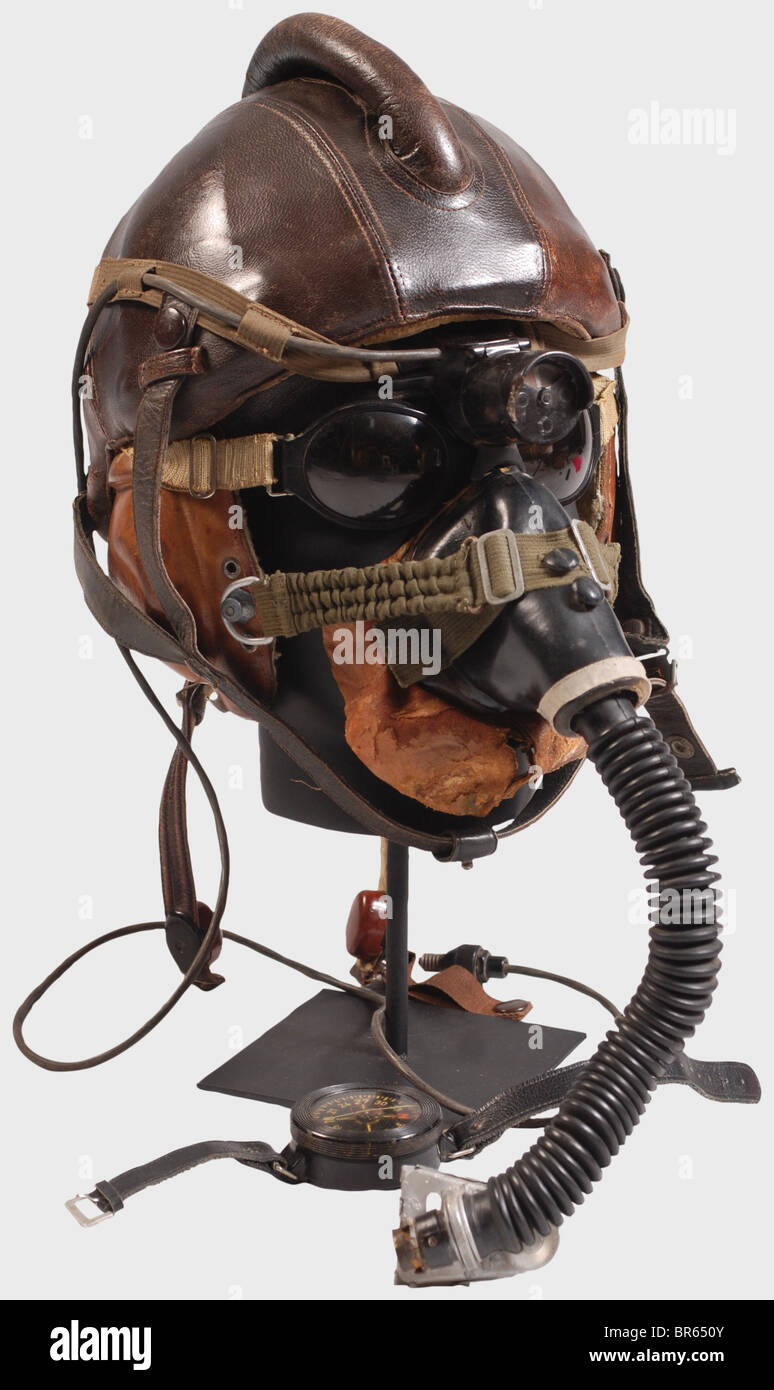 A Luftwaffe fighter pilot in the Reich's air defense., A model SSK 90 pilot's steel helmet. Skull of riveted steel plates with brown leather cover and cylindrical head pad, sand-coloured mottled cotton lining, complete with straps. A LKp S101 sand-coloured, linen flying helmet with brown leather trim, three- historic, historical, 1910s, 20th century, Second World War / WWII, object, objects, clipping, cut out, cut-out, cut-outs, stills, military, militaria, Luftwaffe, German Air Force, branch of service, branches of service, armed service, armed services, utens, Stock Photo