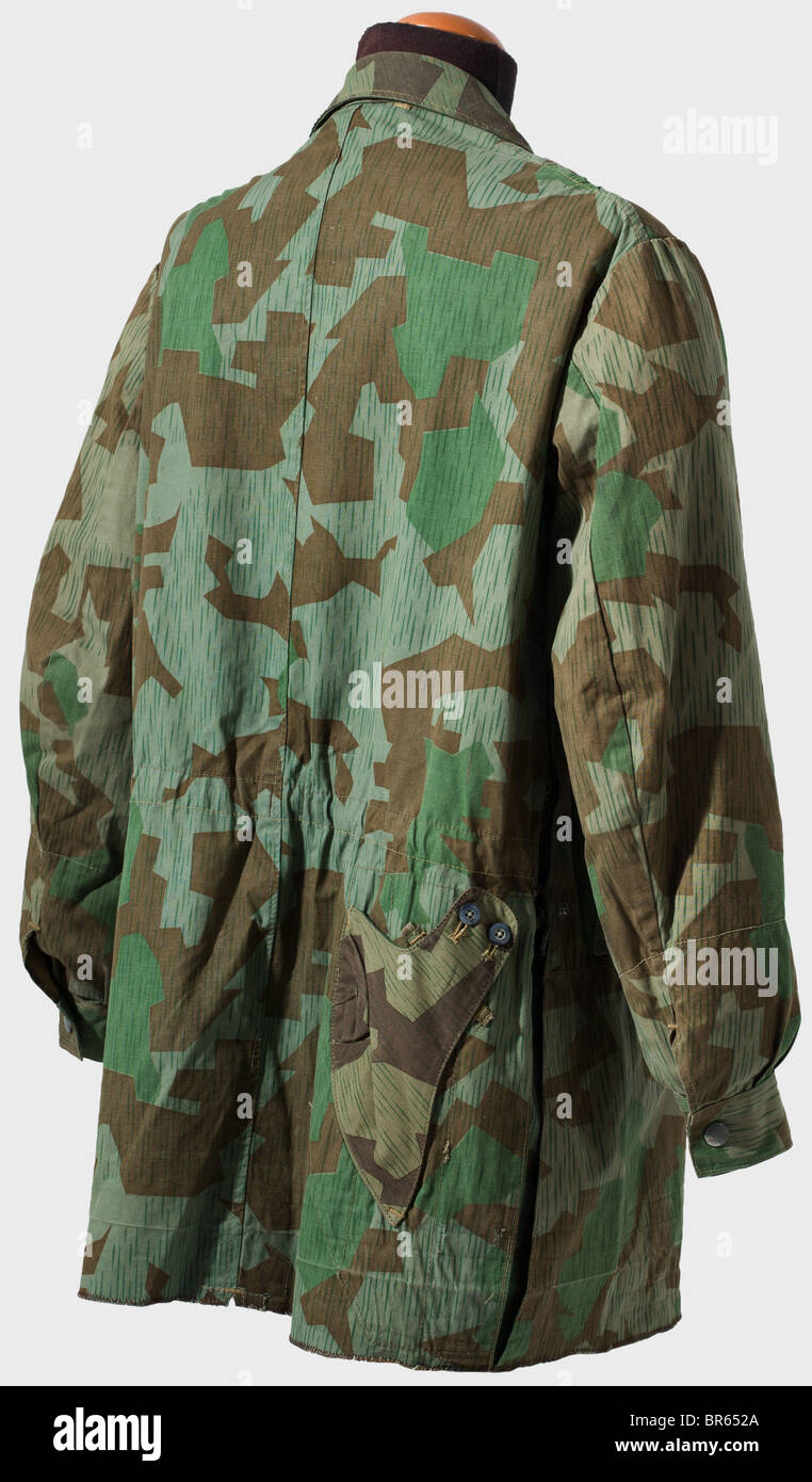 A paratrooper smock, 3rd model., The outside of the cloth is printed with splinter pattern camouflage. The light-coloured linen reinforcements and pocket pouches bear the RB number and size stamps. The interior herringbone twill reinforcement for the pistol holster is in splinter camouflage. Brown artificial silk interior cuffs. Covered row of buttons with five blue glass buttons (the top one is missing), RiRi zippers and 'Pyrm' snaps. Slight signs of wear. The lower edge is hemmed. historic, historical, 1910s, 20th century, Second World War / WWII, object, obj, Stock Photo