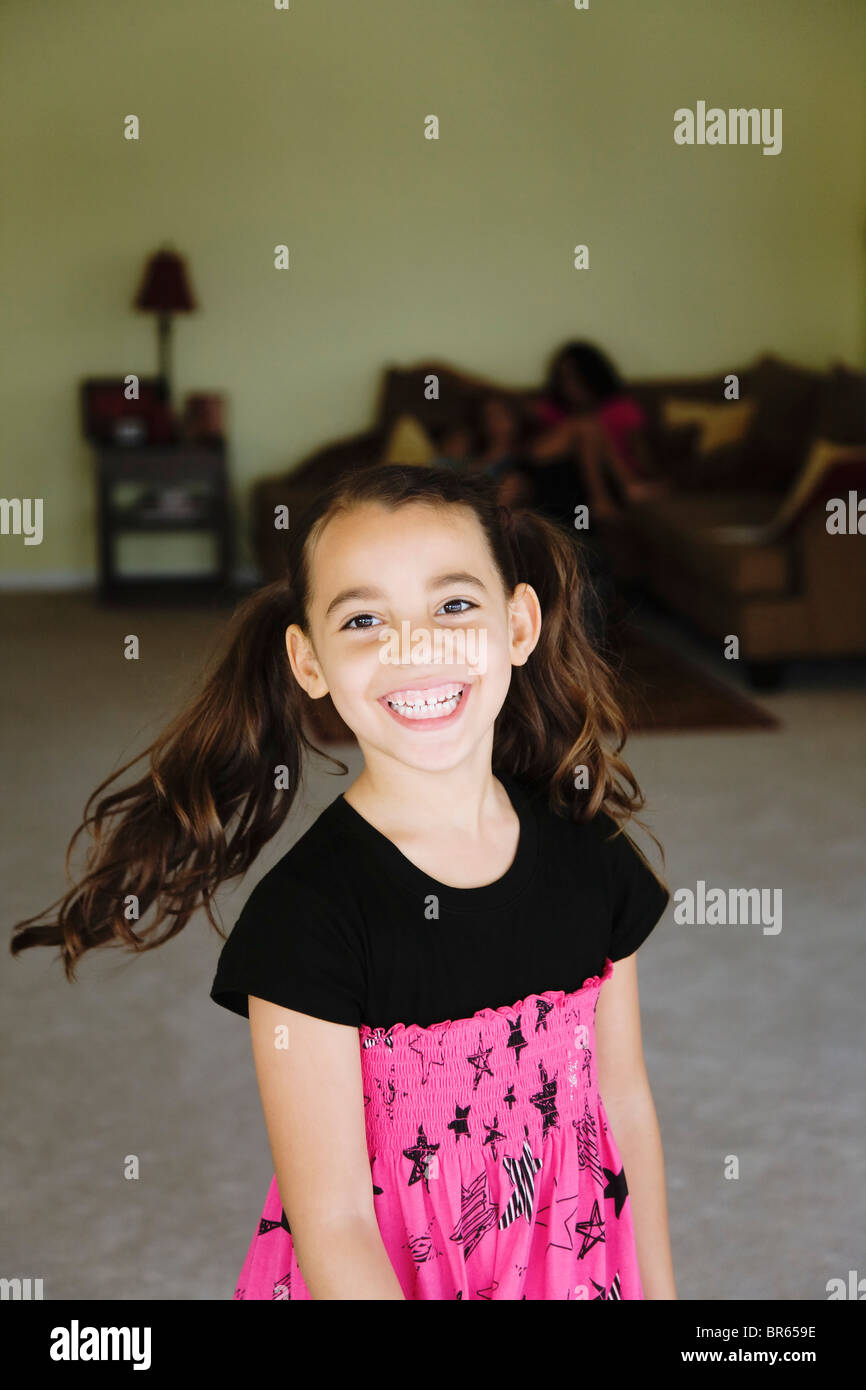 Grinning mixed race girl in living room Stock Photo