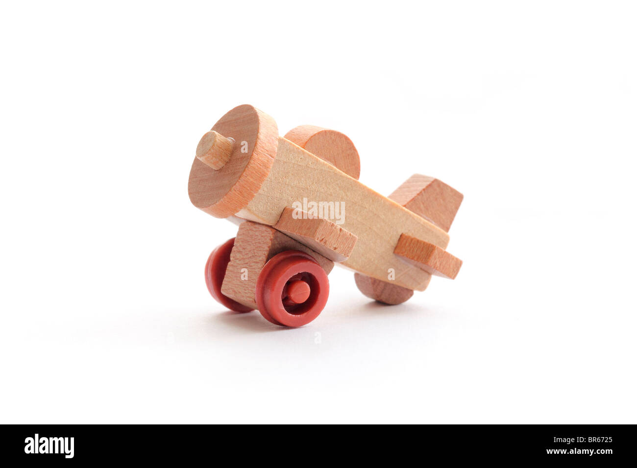 Close-up photograph of a one-inch wooden toy airplane isolated on a white background. Stock Photo