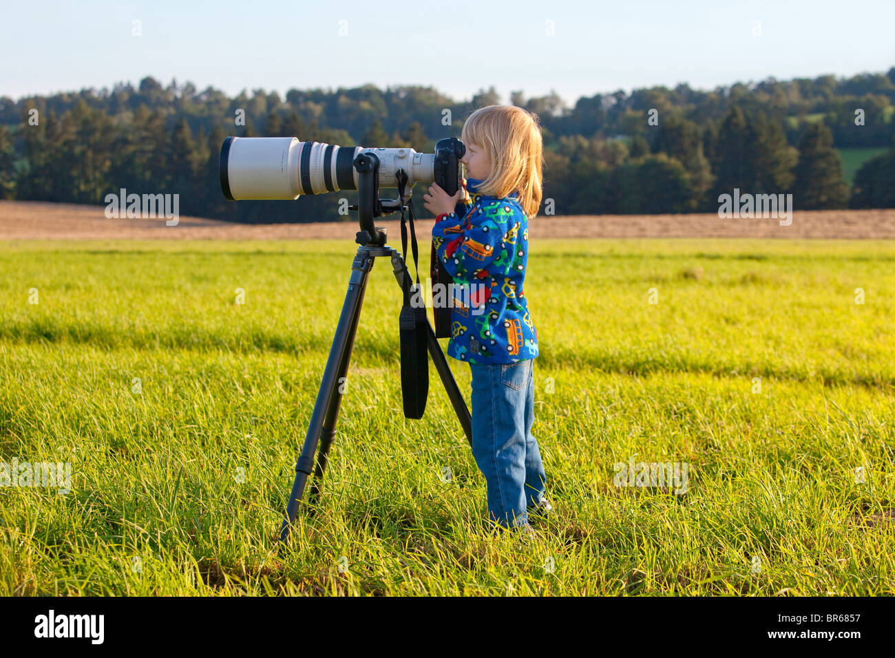 boy looking through super telephoto lens on digital camera Stock Photo