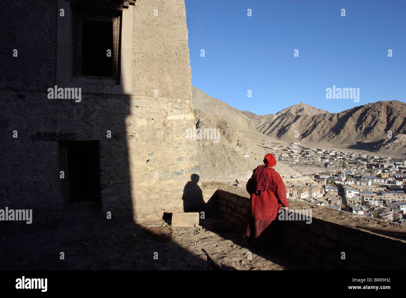 A Buddhist nun looks out over Leh from the Leh Palace in Ladakh, India. Stock Photo