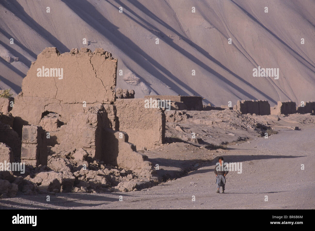 A child passes ruined buildings in the old Bamiyan bazaar Stock Photo