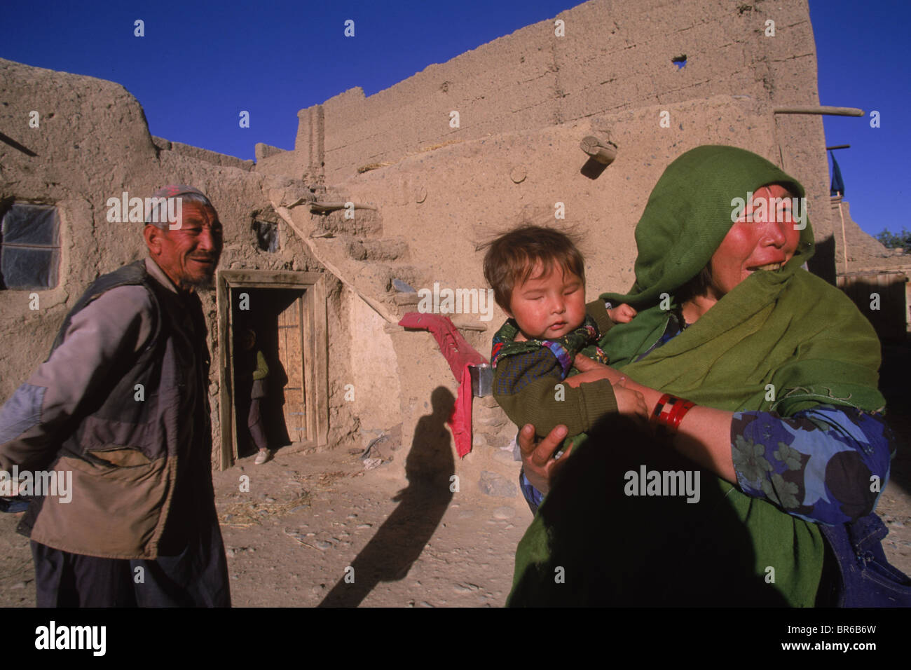 A Hazara family stand outside their home Bamiyan Valley Stock Photo