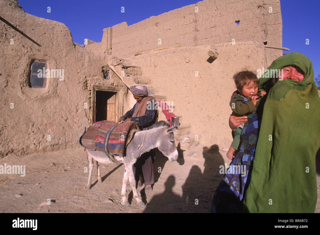 A Hazara family stands outside their home Bamiyan Valley Stock Photo
