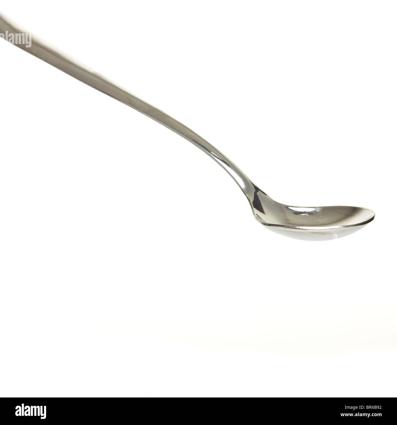 Empty silver desert spoon focus on bowl isolated on white. Stock Photo