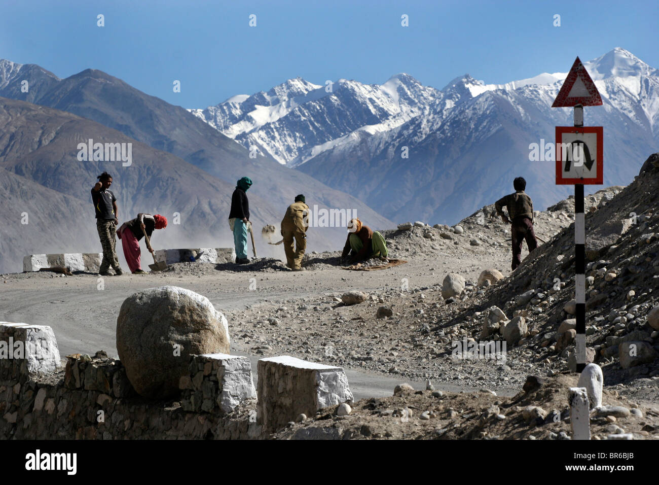 Laborers repair the road to the Khardung La pass, claimed to be the highest motorable road in the world, in Ladakh, India. Stock Photo